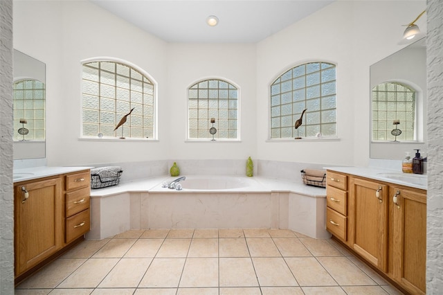 bathroom with tile patterned flooring, a healthy amount of sunlight, vanity, and a garden tub