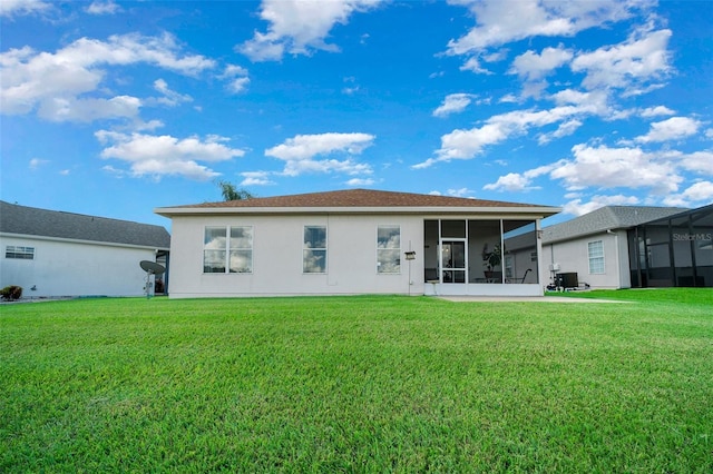 rear view of property featuring cooling unit, a lawn, a sunroom, and stucco siding