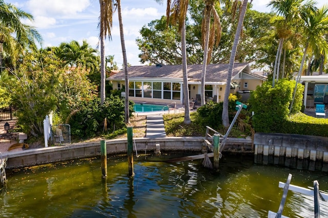 back of house featuring a sunroom, fence, and a fenced in pool