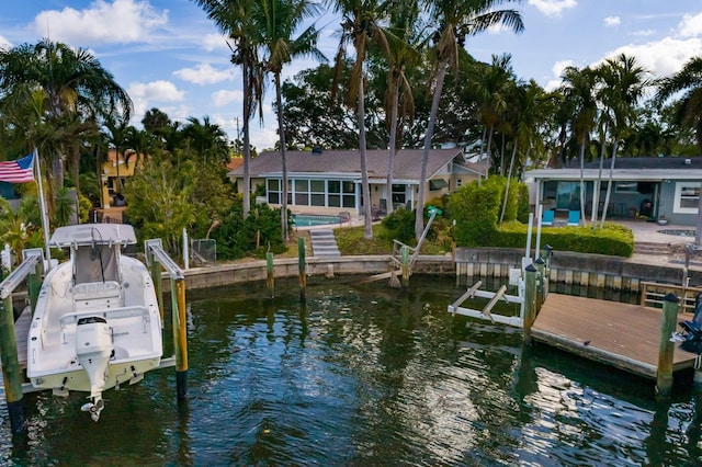 view of dock with a water view, boat lift, and a patio area