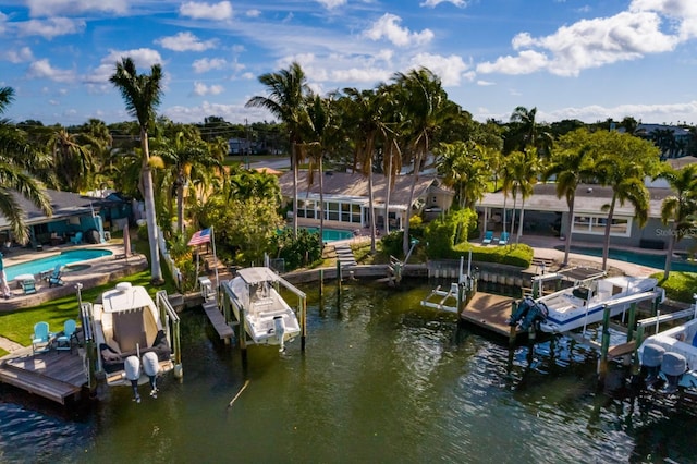 dock area with a water view, a community pool, and boat lift