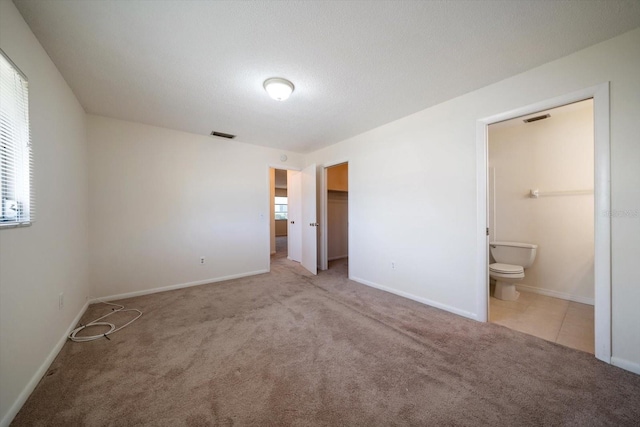 8445 Calais N, Pinellas Park, FL 33781 - unfurnished bedroom with carpet flooring, multiple windows, ensuite bathroom, and baseboards