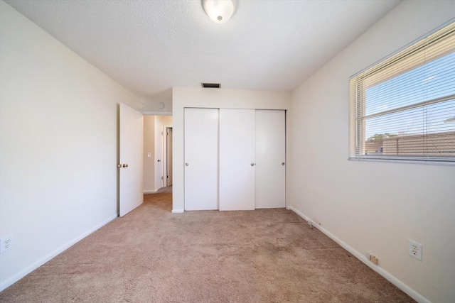8445 Calais N, Pinellas Park, FL 33781 - unfurnished bedroom featuring carpet, a closet, and baseboards