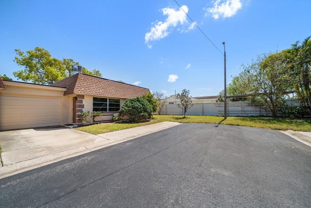 8445 Calais N, Pinellas Park, FL 33781 - view of front facade featuring concrete driveway, a garage, stucco siding, and mansard roof