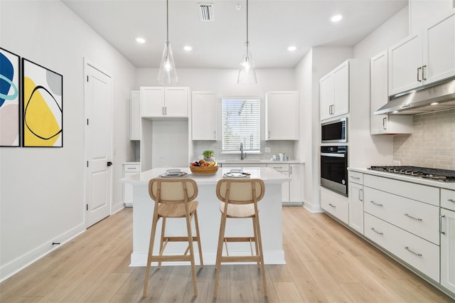 6605 N Nebraska Ave Unit 28, Tampa, FL 33604 - kitchen with appliances with stainless steel finishes, under cabinet range hood, a center island, backsplash, and recessed lighting