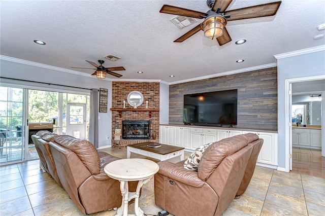 living room with a textured ceiling, visible vents, a fireplace, ornamental molding, and a ceiling fan