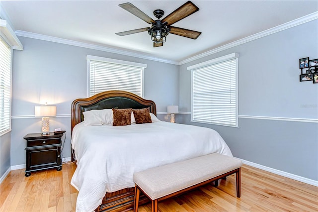 bedroom featuring a ceiling fan, crown molding, light wood-style floors, and baseboards