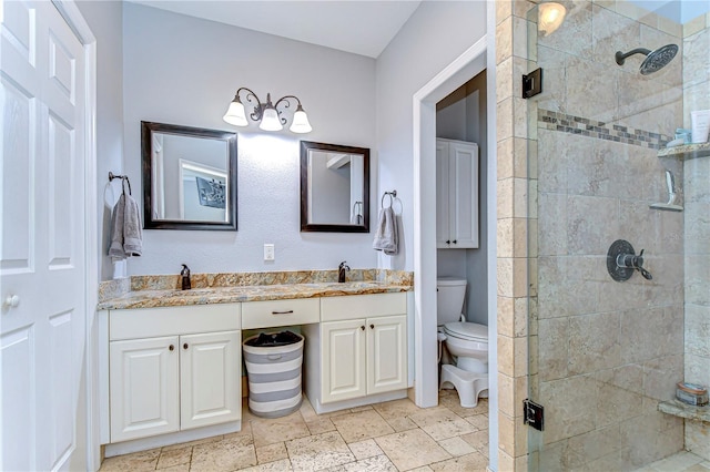 full bathroom featuring toilet, a sink, a shower stall, stone tile flooring, and double vanity