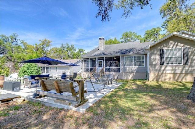 rear view of property featuring a chimney, outdoor lounge area, a shingled roof, a sunroom, and a yard