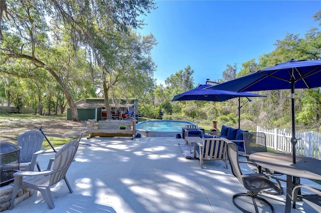view of patio featuring a storage unit, fence, an outdoor pool, and an outdoor structure