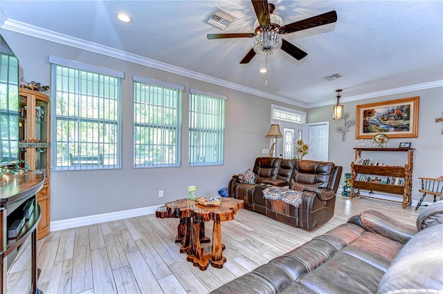living room featuring ceiling fan, visible vents, and crown molding