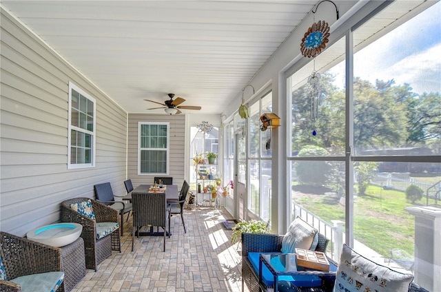 sunroom featuring outdoor dining space, ceiling fan, and a wealth of natural light