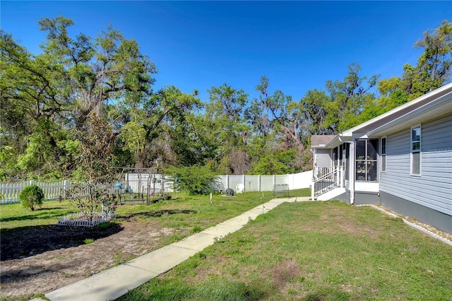 view of yard with a fenced backyard and a sunroom