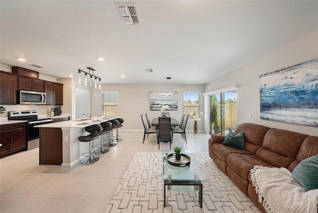 30364 Marquette Ave, Wesley Chapel, FL 33545 - living room featuring light tile patterned floors, recessed lighting, baseboards, and visible vents