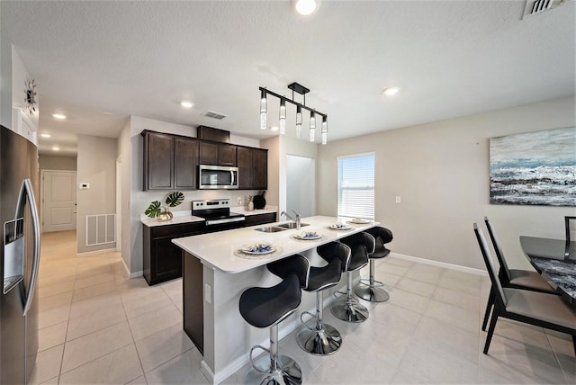 30364 Marquette Ave, Wesley Chapel, FL 33545 - kitchen featuring visible vents, a sink, a kitchen bar, and appliances with stainless steel finishes