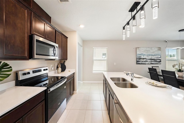 30364 Marquette Ave, Wesley Chapel, FL 33545 - kitchen featuring light countertops, a sink, hanging light fixtures, stainless steel appliances, and dark brown cabinets