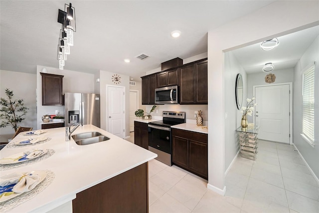 30364 Marquette Ave, Wesley Chapel, FL 33545 - kitchen with light countertops, a sink, light tile patterned floors, stainless steel appliances, and dark brown cabinets