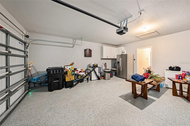 30364 Marquette Ave, Wesley Chapel, FL 33545 - garage featuring concrete block wall, stainless steel fridge, and a garage door opener