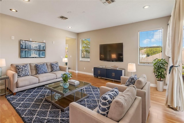 living area featuring wood finished floors, baseboards, and recessed lighting