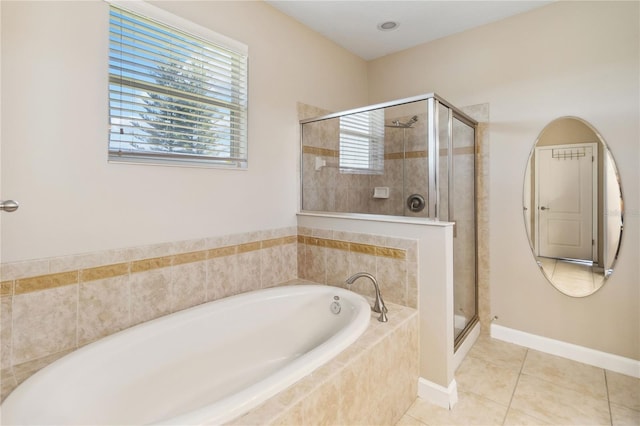 bathroom featuring a shower stall, a garden tub, tile patterned flooring, and baseboards