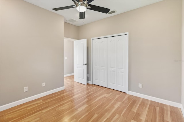 unfurnished bedroom featuring baseboards, light wood finished floors, a closet, and a ceiling fan