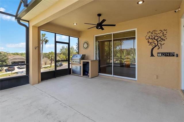 unfurnished sunroom with ceiling fan, plenty of natural light, and an outdoor kitchen