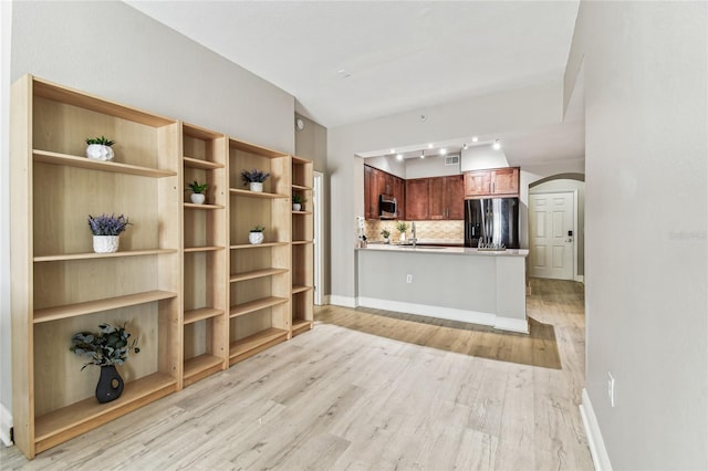 100 4th Ave S Unit 220, Saint Petersburg, FL 33701 - kitchen with appliances with stainless steel finishes, arched walkways, light wood finished floors, a peninsula, and tasteful backsplash