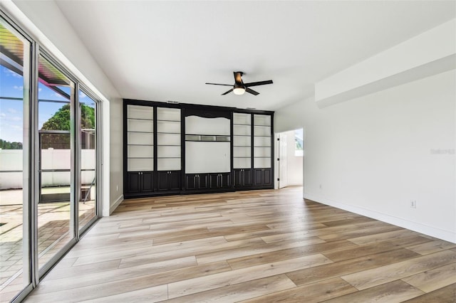 unfurnished room featuring baseboards, a ceiling fan, and wood finished floors