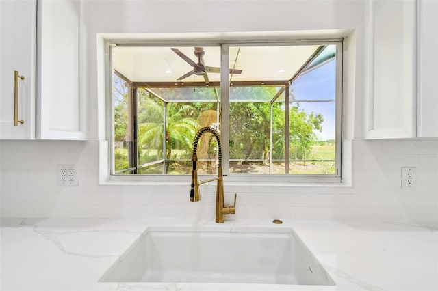 details with a sink, tasteful backsplash, white cabinetry, and ceiling fan