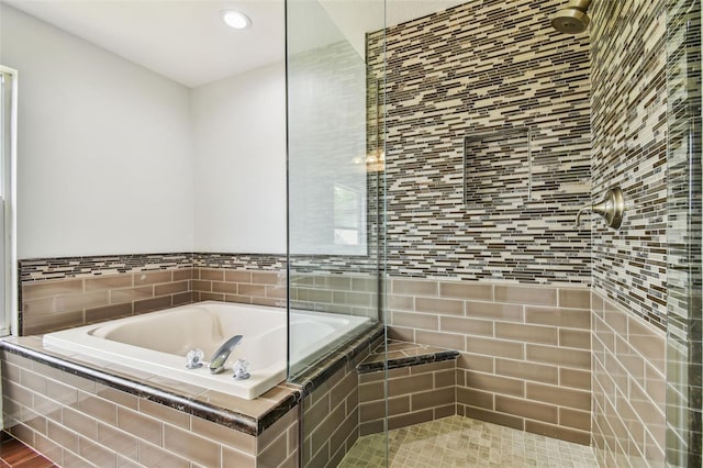 full bath featuring a tile shower and a bath