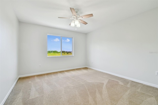 empty room featuring carpet, baseboards, and ceiling fan