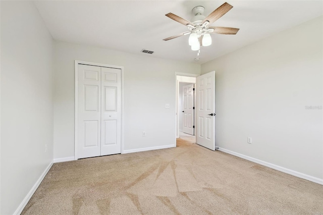 unfurnished bedroom featuring visible vents, baseboards, a closet, and light carpet
