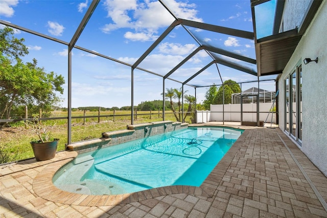 outdoor pool with a hot tub, a patio, and a lanai