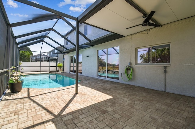 view of swimming pool with a fenced in pool, a patio area, glass enclosure, and ceiling fan