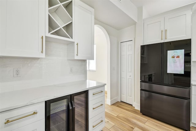 kitchen with white cabinets, arched walkways, decorative backsplash, smart refrigerator, and beverage cooler