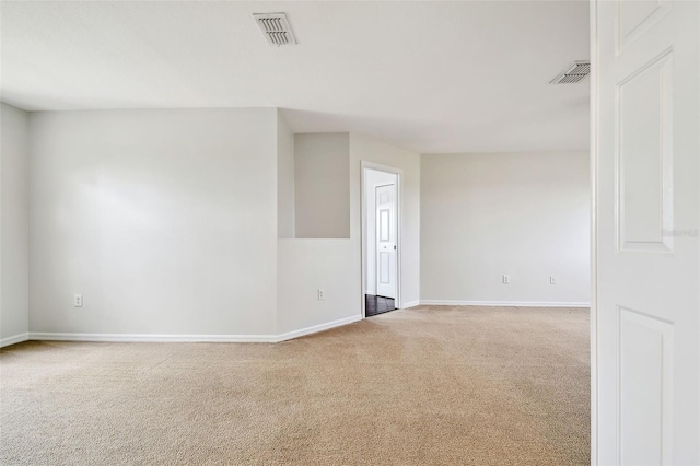 carpeted empty room featuring visible vents and baseboards