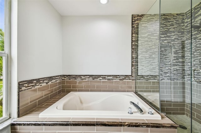 bathroom featuring a shower stall and a bath