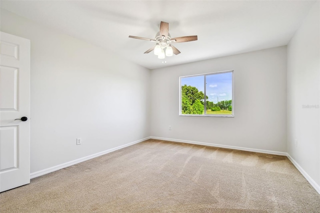 empty room featuring carpet floors, baseboards, and a ceiling fan