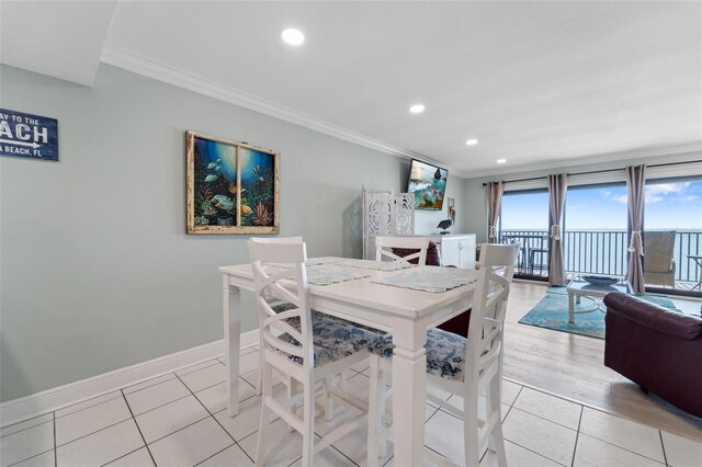 dining space featuring light tile patterned flooring, crown molding, baseboards, and recessed lighting