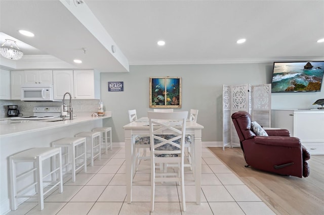 dining space with light tile patterned floors, ornamental molding, baseboards, and recessed lighting