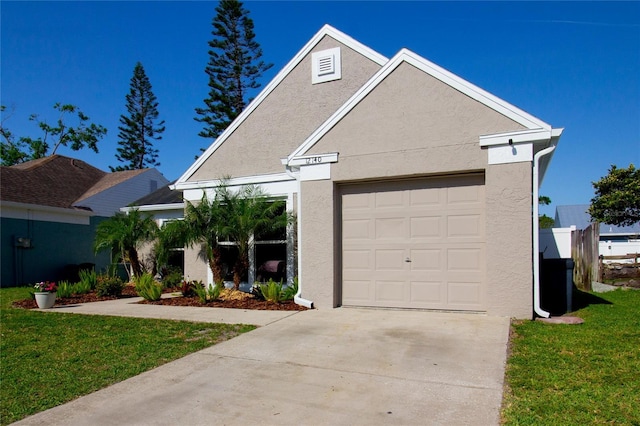 12140 74th St, Largo, FL 33773 - view of front of home with a garage, driveway, stucco siding, and a front lawn