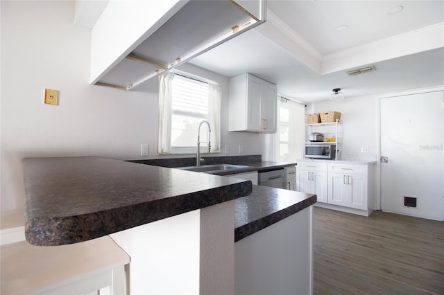 12140 74th St, Largo, FL 33773 - kitchen with a raised ceiling, a sink, white cabinets, appliances with stainless steel finishes, and wood finished floors