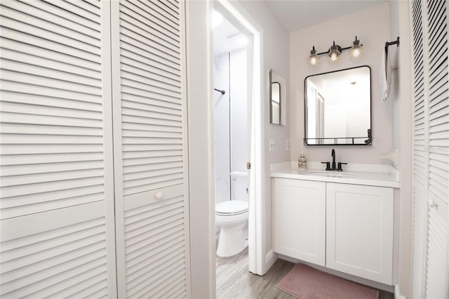 12140 74th St, Largo, FL 33773 - full bathroom with a closet, toilet, a shower, vanity, and wood finished floors