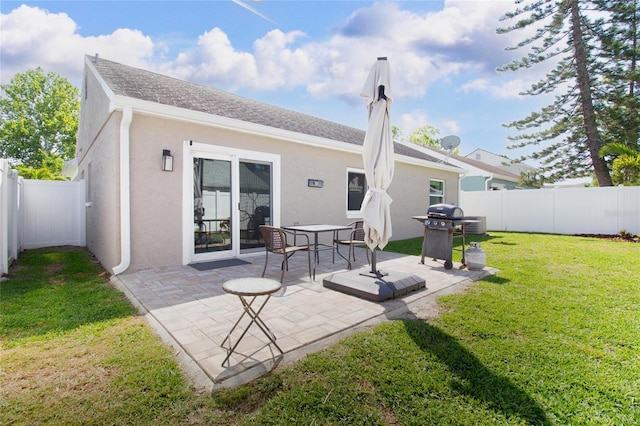 12140 74th St, Largo, FL 33773 - rear view of house featuring a fenced backyard, a lawn, stucco siding, and a patio area