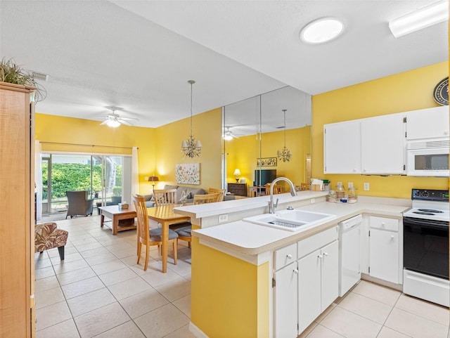 kitchen with white appliances, a peninsula, a sink, light countertops, and open floor plan