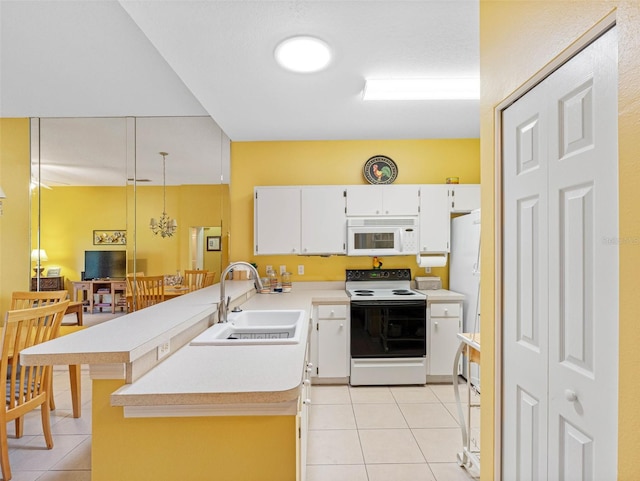 kitchen featuring white appliances, light tile patterned floors, a peninsula, a sink, and light countertops
