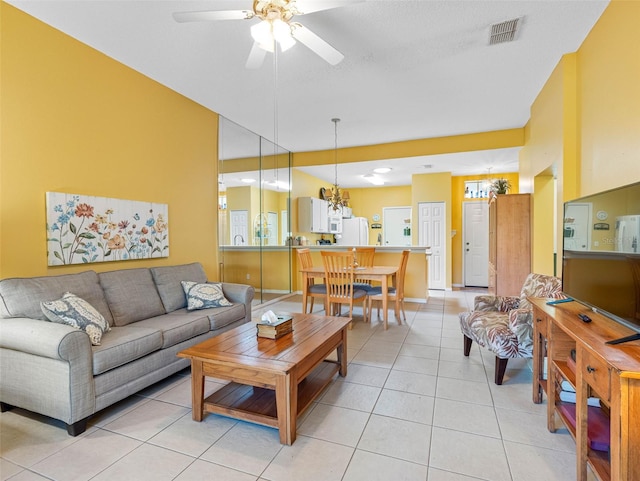 living area with light tile patterned floors, a ceiling fan, and visible vents