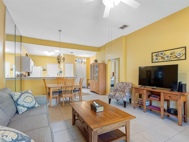 living area featuring light tile patterned floors, a ceiling fan, and visible vents