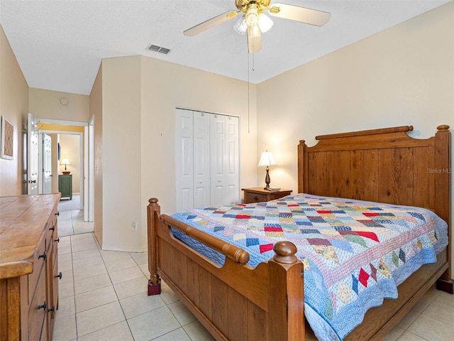 bedroom with ceiling fan, visible vents, a closet, and light tile patterned flooring