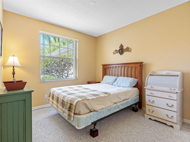 bedroom with carpet flooring, a textured ceiling, and baseboards